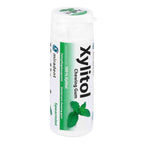 A white plastic bottle of Xylitol Chewing Gum by miradent, featuring a green and white label with a mint leaf graphic, on a plain white background.
