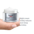 A hand holding an open jar of Eucerin Hyaluron-Filler night cream against a white background, with gray text on the right stating 'Night cream visibly reduces even deep wrinkles'.