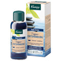 A bottle and box of Kneipp Bade-Essenz Tiefen-Entspannung patchouli and sandalwood bath relaxation liquid on a white background.