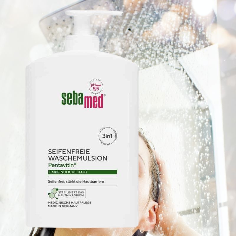 A bottle of Seba med Pentavitin soap-free shampoo in a white pump bottle, shown in front of a blurred background depicting water droplets and a person's ear and hair.