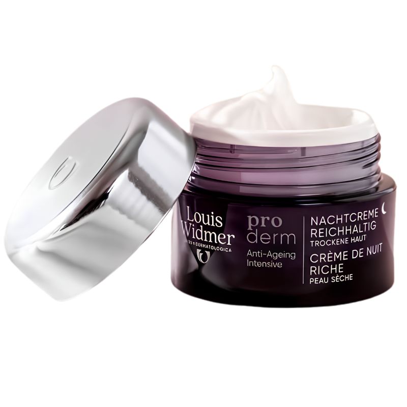 Louis Widmer Proder Nachtcrème anti-ageing dry skin cream in a dark purple jar with a white cream swirl on top, shown with its reflective silver lid leaning against it on a white background.