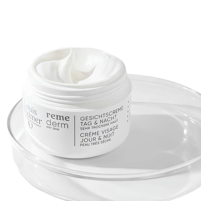 A white jar of Louis Richard Reme Derm dry cream with white cream visible inside, resting on a clear glass dish against a white background.
