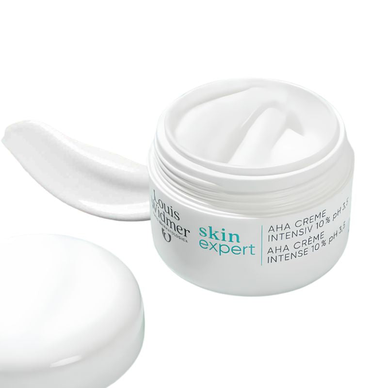 Louis Fer skin expert AHA creme intensive 10% pH 5.5 in a white jar with the cap off, showing a dollop of white cream inside and a separate smear of cream on the left, on a white background.