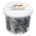 A clear plastic tub filled with dark hexagonal sugar cane sticks, with a white lid printed with the brand name Canea Sweets and German text.
