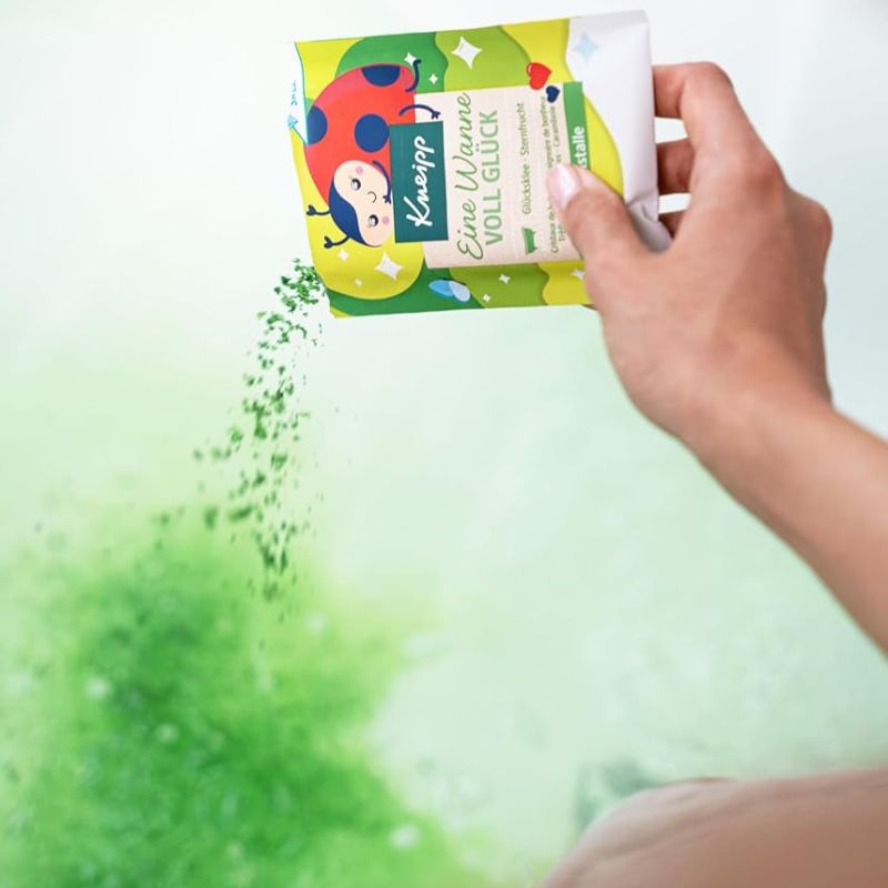 A hand holds a package of Kaippa ladybug-shaped gel packs above a green powder spill on a white background.
