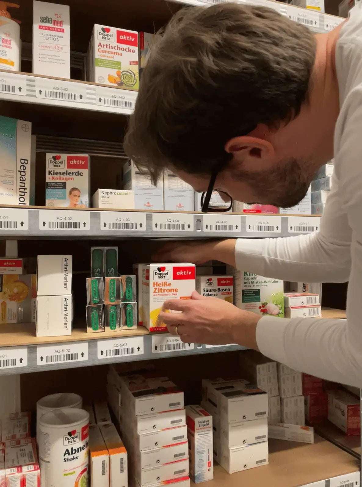 A VicNic team member stocking authentic Doppelherz supplements and German pharmacy brands on the shelves of our physical warehouse in Hamburg, Germany.