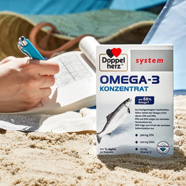 Lifestyle photo of the Doppelherz Omega- concentrate at the beach while doing a brain jogging exercise