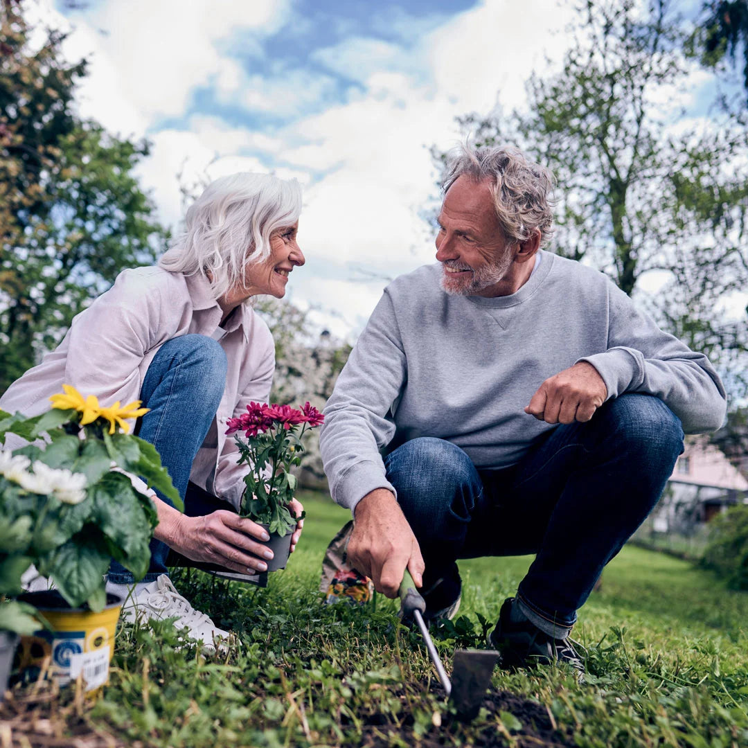 Couple in the garden, looking healthy and being able to move without knee pain.