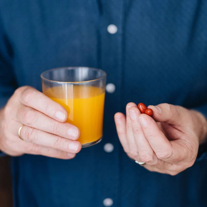 Orthomol Chondroplus stirred into a glas of water. 2 capsules are hold on the other hand.