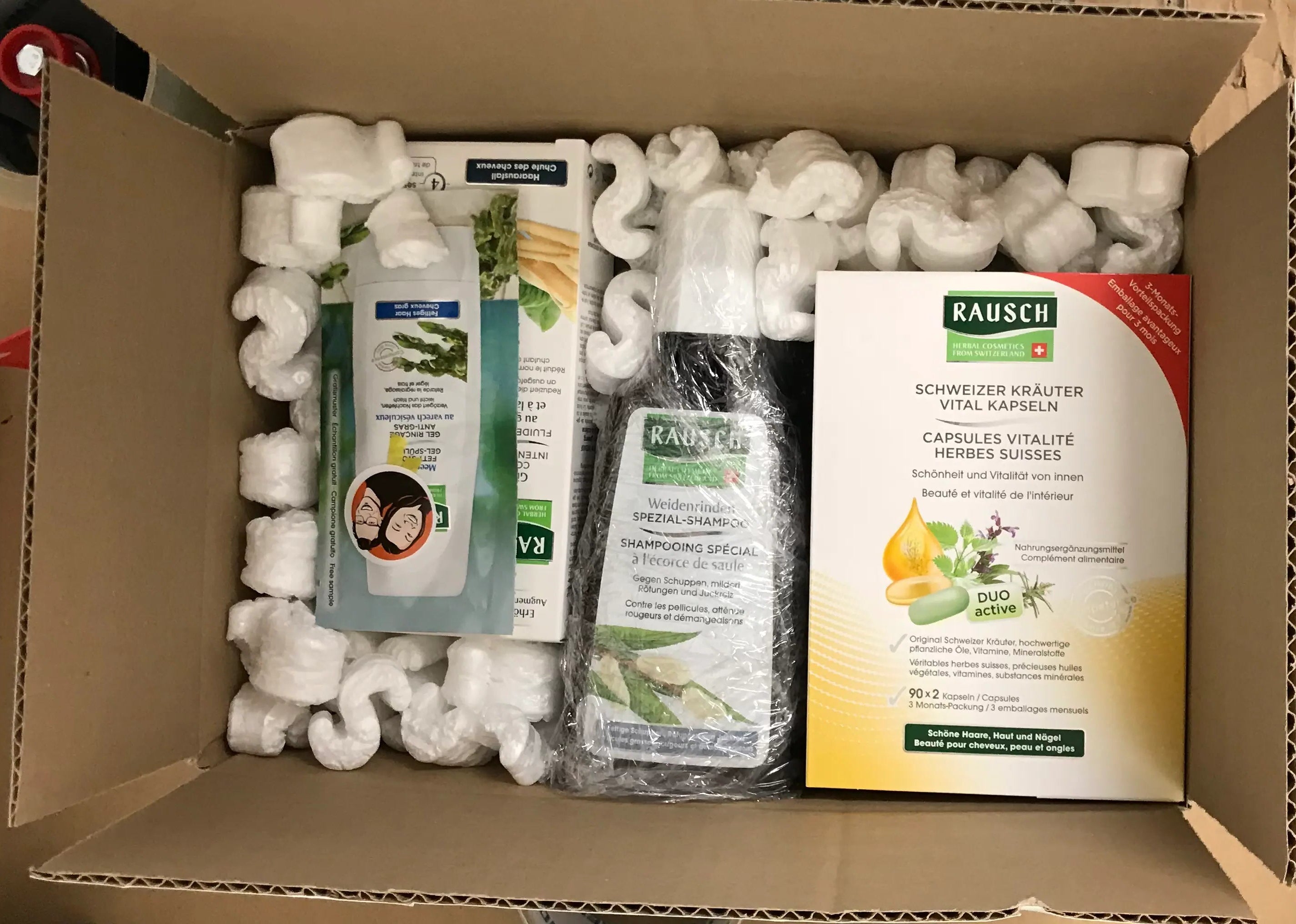 An open VicNic shipping box securely packed with authentic Rausch products, fully protected for international shipping using eco-friendly packing chips made from natural materials.